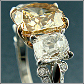 2ct cushion cut champagne diamond, 2 cushion cut side diamonds, and 50 small diamonds in shank.